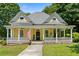 Charming yellow two-story home with inviting front porch, lush landscaping, and American flag at 161 N Barton St, Norcross, GA 30071