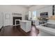 Bright kitchen with white cabinets, stainless steel appliances, central island, wood floors, and a decorative fireplace at 161 N Barton St, Norcross, GA 30071