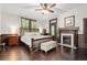 Bedroom with hardwood floors, a wooden bed frame, an area rug, and a fireplace in the corner at 161 N Barton St, Norcross, GA 30071