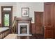Bedroom with a decorative fireplace, hardwood floors, dark wooden trim, and a view of the yard outside at 161 N Barton St, Norcross, GA 30071