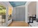 Enclosed sunroom with wood flooring, view to outdoor porch, and extra storage behind grey paneled doors at 161 N Barton St, Norcross, GA 30071