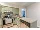 An updated kitchen features stainless steel appliances, a breakfast bar, and modern fixtures at 215 Cobblestone Trl, Avondale Estates, GA 30002