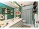 Vintage-style bathroom features bold green wallpaper, a spacious vanity, and a tub/shower combo at 3099 Farmington Se Dr, Atlanta, GA 30339