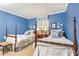 Bedroom showcasing two twin beds, blue walls, and windows providing natural light at 3099 Farmington Se Dr, Atlanta, GA 30339