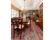 Dining room with a stone fireplace, a large table, and vintage decor leading to a staircase, exuding charm at 3099 Farmington Se Dr, Atlanta, GA 30339