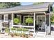 Charming front porch featuring lush greenery, plants, hanging ferns, and outdoor seating at 3099 Farmington Se Dr, Atlanta, GA 30339