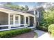 Inviting front porch with white railings and a tiled floor leading to a dark front door, framed by greenery at 3099 Farmington Se Dr, Atlanta, GA 30339