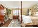 Main bedroom with stone fireplace, four-poster bed, wooden floors, and neutral color scheme at 3099 Farmington Se Dr, Atlanta, GA 30339