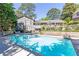 Backyard view showcasing a sparkling pool and a well-maintained home with a fenced yard and lush landscaping at 3099 Farmington Se Dr, Atlanta, GA 30339