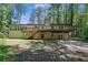 Expansive backyard featuring a deck, patio, brick exterior, and views of mature trees at 4066 Covered Bridge Sw Rd, Smyrna, GA 30082