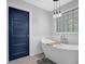 Bathroom featuring soaking tub, modern fixtures, and a blue painted door at 4066 Covered Bridge Sw Rd, Smyrna, GA 30082