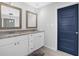 Bathroom featuring double vanity, granite countertops, modern fixtures, and a blue painted door at 4066 Covered Bridge Sw Rd, Smyrna, GA 30082