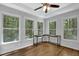Bright bedroom featuring hardwood floors, a ceiling fan, and large windows offering natural light and wooded views at 4066 Covered Bridge Sw Rd, Smyrna, GA 30082