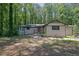 Charming one-story home featuring a brick facade, red door, mature trees, and a welcoming front entrance at 4066 Covered Bridge Sw Rd, Smyrna, GA 30082