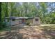 A charming one-story home with a brick facade, red door, mature trees, and welcoming front entrance at 4066 Covered Bridge Sw Rd, Smyrna, GA 30082