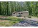 Side exterior of a brick house featuring a well-maintained lawn and driveway surrounded by lush greenery at 4066 Covered Bridge Sw Rd, Smyrna, GA 30082