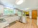 Bright kitchen with white cabinets, granite countertops, stainless steel appliances, and wood-look floors at 410 Hunters Cove Ct, Lawrenceville, GA 30044