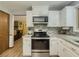 Well-lit kitchen with white cabinetry, stainless steel appliances, granite countertops and mosaic tile backsplash at 410 Hunters Cove Ct, Lawrenceville, GA 30044