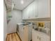 Bright laundry room features washer, dryer, utility sink, and white cabinets for storage at 410 Hunters Cove Ct, Lawrenceville, GA 30044