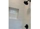 Modern bathroom featuring a walk-in shower with black fixtures, a built-in shelf, and white tile at 4756 Manly Ct, Stone Mountain, GA 30088