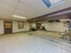 Unfinished basement with exposed ceiling, brick fireplace, and concrete floor at 2000 Stone Mountain Lithonia Rd, Lithonia, GA 30058
