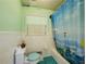 Retro bathroom design with a blue toilet, hot air ballon shower curtain, and white tiled walls at 2000 Stone Mountain Lithonia Rd, Lithonia, GA 30058