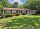 Charming one-story brick home featuring a well-maintained lawn and mature trees at 2000 Stone Mountain Lithonia Rd, Lithonia, GA 30058