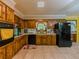 Cozy kitchen featuring wood cabinetry, black appliances, and tile flooring at 2000 Stone Mountain Lithonia Rd, Lithonia, GA 30058