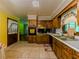 Well-lit kitchen with wood cabinets, black appliances, and tile floors at 2000 Stone Mountain Lithonia Rd, Lithonia, GA 30058