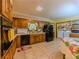 Functional kitchen with wood cabinets and black appliances, including laundry area at 2000 Stone Mountain Lithonia Rd, Lithonia, GA 30058