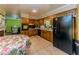 Functional kitchen with wood cabinetry, black appliances, and access to living area at 2000 Stone Mountain Lithonia Rd, Lithonia, GA 30058