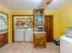 Bright yellow laundry area with washer, dryer, shelving, and storage cabinet at 2000 Stone Mountain Lithonia Rd, Lithonia, GA 30058