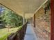 A cozy, covered side porch with brick wall and wood railing at 2000 Stone Mountain Lithonia Rd, Lithonia, GA 30058