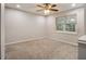 An empty bedroom features neutral carpet, gray walls, a window, and a ceiling fan at 3149 Buford Hwy # 3, Brookhaven, GA 30329
