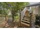 View of the home's backyard with wooden stairs leading up to a deck, and a wooden fence at 377 Wyndham Way, Atlanta, GA 30315