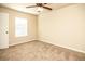 Carpeted bedroom featuring a ceiling fan, light filled window, and a white door at 610 Sunflower Dr, Canton, GA 30114