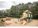 Community playground featuring a slide, swings, and seating with a wooded backdrop at 610 Sunflower Dr, Canton, GA 30114