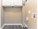 This laundry room has gray vinyl floors and overhead storage at 881 Mercury Nw Dr, Atlanta, GA 30331