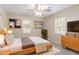 Staged bedroom features large bed, wood dresser, ceiling fan and two windows at 881 Mercury Nw Dr, Atlanta, GA 30331