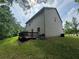View of the backyard featuring a deck and lush green grass, surrounded by trees at 12351 Styron Dr, Hampton, GA 30228