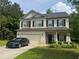 Charming two-story home with a well-manicured lawn and an attached two-car garage at 12351 Styron Dr, Hampton, GA 30228