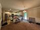 Open kitchen with stainless steel appliances, white cabinets, and an island under the light of a chandelier at 12351 Styron Dr, Hampton, GA 30228
