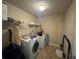 Laundry room with a washer, dryer, wire shelving, and neutral-toned walls with a neutral floor at 12351 Styron Dr, Hampton, GA 30228