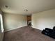 Spacious living room featuring carpet, neutral walls, and an open layout under the light of a ceiling light at 12351 Styron Dr, Hampton, GA 30228