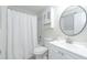Bright bathroom boasts a shower with curtain, a vanity sink, and decorative mirror at 2125 Jessica Way, Lithonia, GA 30058