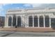 Exterior view of a white brick commercial building with arched doorways and a bench in front at 2125 Jessica Way, Lithonia, GA 30058