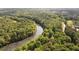 Overhead shot of a tranquil river winding through dense trees, showcasing the natural landscape and serene setting at 3390 River Ferry Dr, Alpharetta, GA 30022