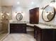 View of a bathroom featuring double vanities, granite counters, dark wood cabinets, and glass shower at 3390 River Ferry Dr, Alpharetta, GA 30022