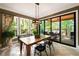 Bright dining room with modern light fixture and sliding glass doors leading to an outdoor porch at 3390 River Ferry Dr, Alpharetta, GA 30022
