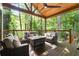 Cozy outdoor porch with comfortable seating, a fire pit, and views of a lush, green backyard at 3390 River Ferry Dr, Alpharetta, GA 30022